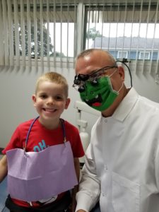 A man and boy with face paint in the dentist 's office.
