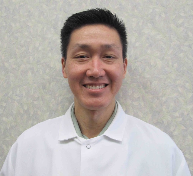 A man in white shirt smiling for the camera.