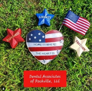 A heart and stars on the grass with some other patriotic items.