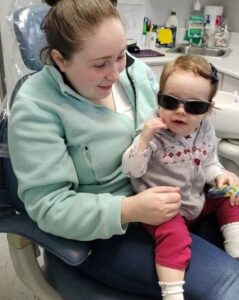 child wearing sunglasses and her mother