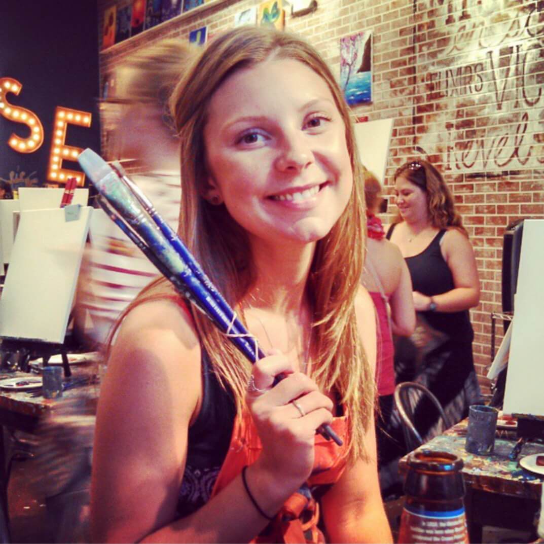 A girl holding a tennis racket in her hand.